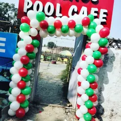 A classic red, white, and green balloon arch installed at the entrance of a pool cafe, perfect for creating a welcoming, festive look for Christmas.