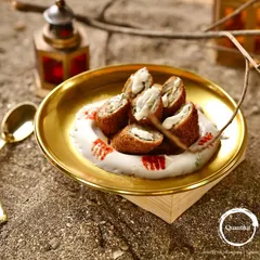 A wider view of the Chicken and Cheese Swiss Rolls, presented on a wooden block with rustic cutlery, perfect for a stylish event.