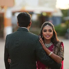 The bride looking back with a smile. This shot shows how the simple maang tikka and necklace create an elegant and modern bridal style.