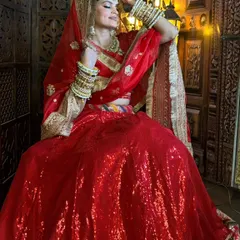 For the classic bride, nothing beats a stunning red lehenga. I've paired this sequined outfit with a complete gold-toned bridal jewellery set, including a choker, maang tikka, and stacked bangles, to create a timeless and royal wedding look.