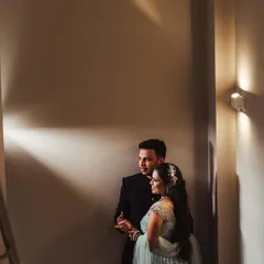 A beautifully lit portrait in a hallway, using wall sconces to create pools of light. This shot of Shweta and Onkar has a cinematic and intimate feel.