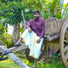 A stylish portrait of the groom in traditional attire, posing on a rustic bullock cart. This shot has a classic, masculine charm.