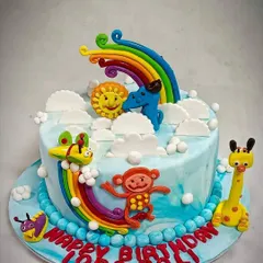 A custom birthday cake for a children's party. This colourful creation features a rainbow and adorable animal fondant figures, designed to match the party's theme and bring a smile to the birthday child's face.