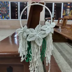 This macrame floral wreath was used as a pew decoration for the wedding. The three knotted flowers add a beautiful, textural detail.