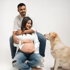 The whole pack. This pose shows the beautiful connection between the couple and their dog, who is looking on with curiosity and love. It's a perfect family portrait.