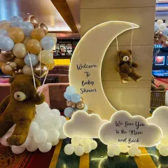 There is nothing sweeter than a teddy bear theme, and this 'We Love You to the Moon and Back' setup is one of our favorites. The soft lighting, cloud-like balloons, and adorable bears create a warm, dreamy atmosphere for a truly memorable baby shower.