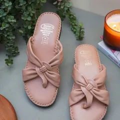 A cozy, atmospheric shot of the same beige sandals next to a lit candle and a book. This styling creates a feeling of comfort and relaxation.