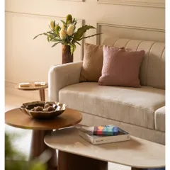 We focused on texture in this living room, with a comfortable cream sofa, nested coffee tables in wood and marble, and soft throw pillows.