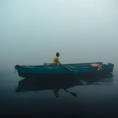 A lone boatman in a yellow shirt drifts through the dense morning fog. This shot captures the feeling of solitude and peace you can find at the ghat, even in a bustling city like Delhi.