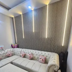 See how our WPC panels can be integrated with custom lighting. This living room uses dark fluted panels with vertical LED strips to create a warm, ambient glow, highlighting the texture of the wall and making the space feel cozy and modern.