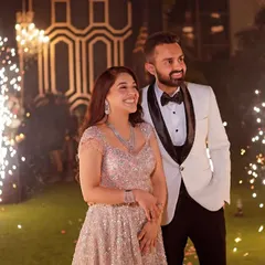 A picture-perfect reception moment. The couple smiles as sparklers go off behind them, creating a beautiful and celebratory portrait.