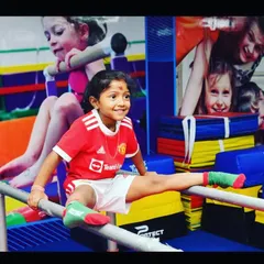 The smile of achievement. We celebrate every milestone, like mastering a split on the parallel bars, which builds not just flexibility but also immense self-confidence and body awareness.