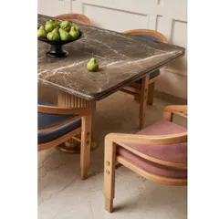 The dining space is subtle yet impactful, with a bespoke marble-topped table and custom chairs upholstered in contrasting colors. The design is clean, elegant, and functional.