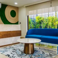 The reception area of the Prestige TechZone office features a vibrant blue sofa and custom wall art, creating a welcoming and modern first impression for visitors. We design our commercial interiors to reflect your brand's identity.