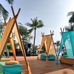 For a relaxed and modern vibe, I offer unique seating like these teepee-style cabanas. Shown here with turquoise and yellow fabrics, they are perfect for a daytime Mehendi or a poolside party.