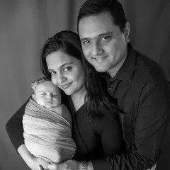 A classic family portrait, converted to black and white. It creates a timeless, elegant look that focuses on the family's happy expressions.