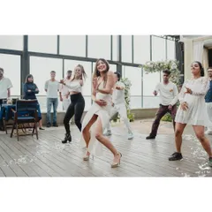 The surprise proposal begins with a dance. This shot captures the bride-to-be leading a choreographed flash mob, full of energy and excitement, just moments before the big question.