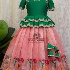This lehenga features a pink organza skirt with a colorful bird and floral print border. The green peplum blouse has matching embroidery.