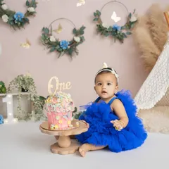 A beautiful setup for a beautiful girl. This boho-themed cake smash features a custom cake, a lace teepee, and delicate floral details.