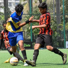 Two players battling for the ball, showing the competitive spirit we foster in our training. We teach our players to be strong and fair in every challenge.