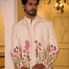 This ivory coord set, featuring vibrant floral hand-embroidery, is designed for daytime celebrations. It offers a fresh, modern take on traditional groomswear, perfect for a Sangeet or Mehendi ceremony.