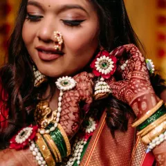 A close-up on the details for this mama-to-be's baby shower. The winged eyeliner, traditional nath, and floral jewelry complete her beautiful look.