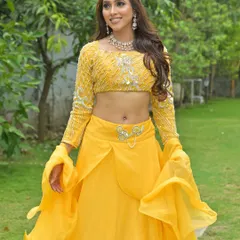A full-length view of the vibrant yellow lehenga, showcasing its unique design and flowy sleeves. A fun and fashionable rental choice for your Haldi.