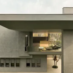 This view frames the interior living space from the outside, revealing the home's dual function as a gallery. The architecture creates a proscenium arch, blurring the lines between inside and out.