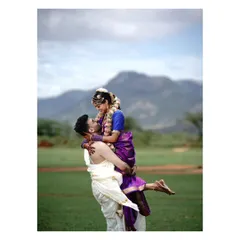 A joyful lift against a mountain backdrop. This post-wedding photo in traditional South Indian attire captures pure happiness and the grandeur of the destination.