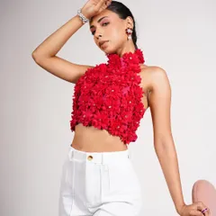 A full-length shot of the red floral appliqué halter top paired with high-waisted white trousers. The styling is clean and vibrant, perfect for a summer collection lookbook.