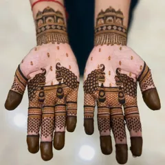 A simple yet elegant design featuring majestic peacocks on the palms, with fingertips dipped in dark henna for a classic bridal look.