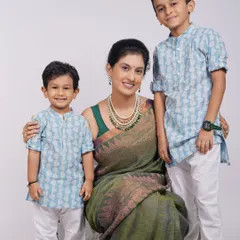 A beautiful family portrait of a mother with her two sons. Dressed in coordinated traditional outfits, this studio shot is a timeless keepsake.