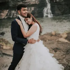 An intimate and tender embrace with a waterfall in the background. The contrast between the powerful nature and their quiet moment makes this pre-wedding photo incredibly romantic.
