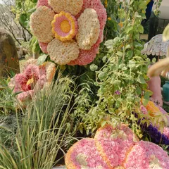 A close-up of a large flower sculpture, created by layering thousands of individual flower heads to achieve rich color and texture.