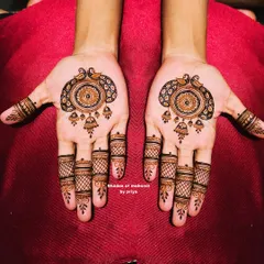 A symmetrical design featuring a mandala with peacocks and jhumkas (earrings). The fingers have a classic mesh or 'jaali' pattern.