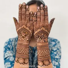 A gorgeous floral and paisley design covering the back of the hands and wrists. The pattern is dense and symmetrical, perfect for a traditional bridal look.