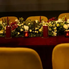 A royal tabletop setting with a rich red velvet cloth and a runner of white and red flowers. This setup is a must for a special day that calls for regal aesthetics.