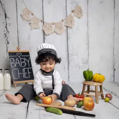 He's carefully inspecting an apple, fully engaged in his role as a baby chef. I love capturing these moments of intense focus and curiosity.