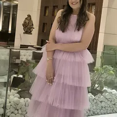 A happy client looking like a real-life Barbie in this custom lavender tiered dress. The soft tulle fabric and halter neck design make it a fun and fashionable choice for birthdays or parties.