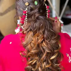 A stunning and unique ponytail for a pre-wedding event. The colorful stone accessories and floral details woven into the hair create a fun and festive look.