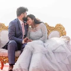 A closer portrait of the couple on a beautiful ornate bench. The groom's tender kiss on the bride's forehead and her happy smile capture a perfect moment of intimacy.