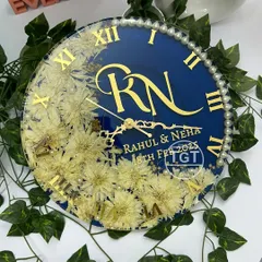 This view shows the floral clock set against a background of green leaves, highlighting the natural element of the preserved flowers.