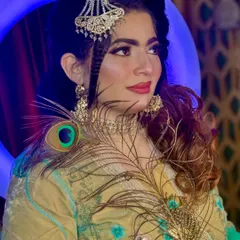 A beautiful portrait from a creative shoot, using a peacock feather as a prop. The makeup is soft and glamorous, with a focus on the eyes and a beautiful hairstyle.