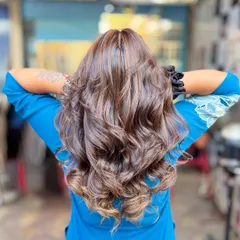 A soft blonde hair color achieved without bleach. This look adds gentle, warm highlights to a dark base for a subtle and natural-looking enhancement.