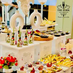 My approach to designer catering is about creating a complete sensory experience. This buffet setup features multi-level displays, artistic decor elements, and a vibrant array of appetizers, ensuring the food presentation is as impressive as the taste.