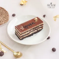 A tribute to French patisserie, our Coffee Opera cake features layers of almond sponge soaked in coffee syrup, coffee buttercream, and chocolate ganache.