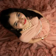 A beautiful high-angle shot looking directly at the camera. The soft folds of the peach gown create a lovely frame for this engaging portrait.