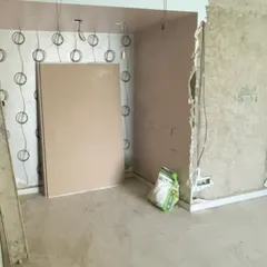 The unfinished corner shows exposed wiring and wall preparation before our backlit pooja unit was installed in this space.