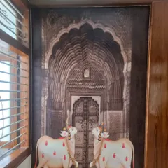 This stunning custom wallpaper depicts two decorated cows in front of an intricately detailed temple doorway, a classic theme from traditional Indian art.