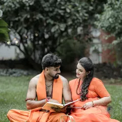 A candid interaction during the themed photoshoot, where the couple shares a book and a smile in a natural, grassy setting. This blends the epic theme with a simple, relatable moment.